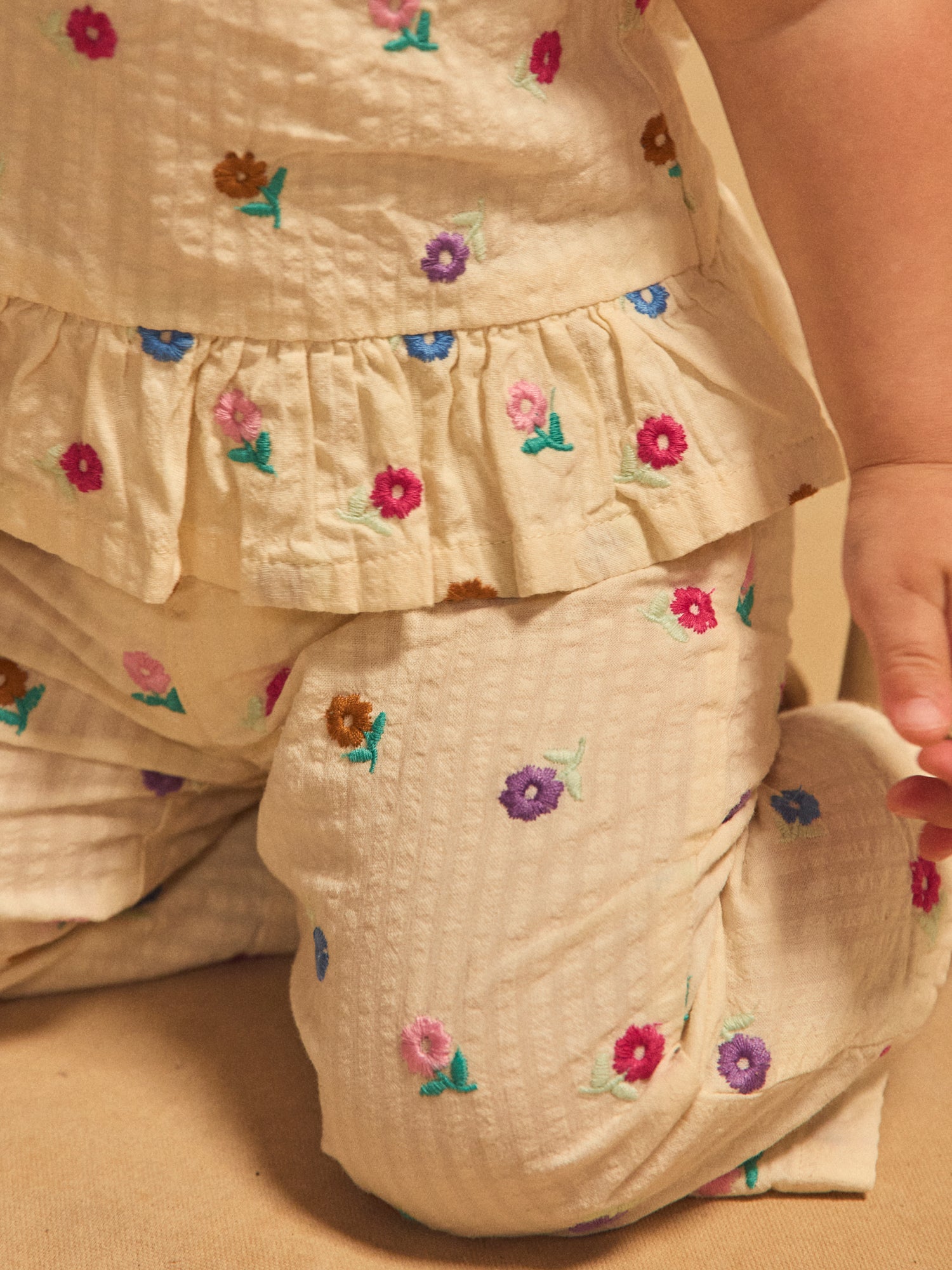 Pantalones crema con bordado floral para bebé niña