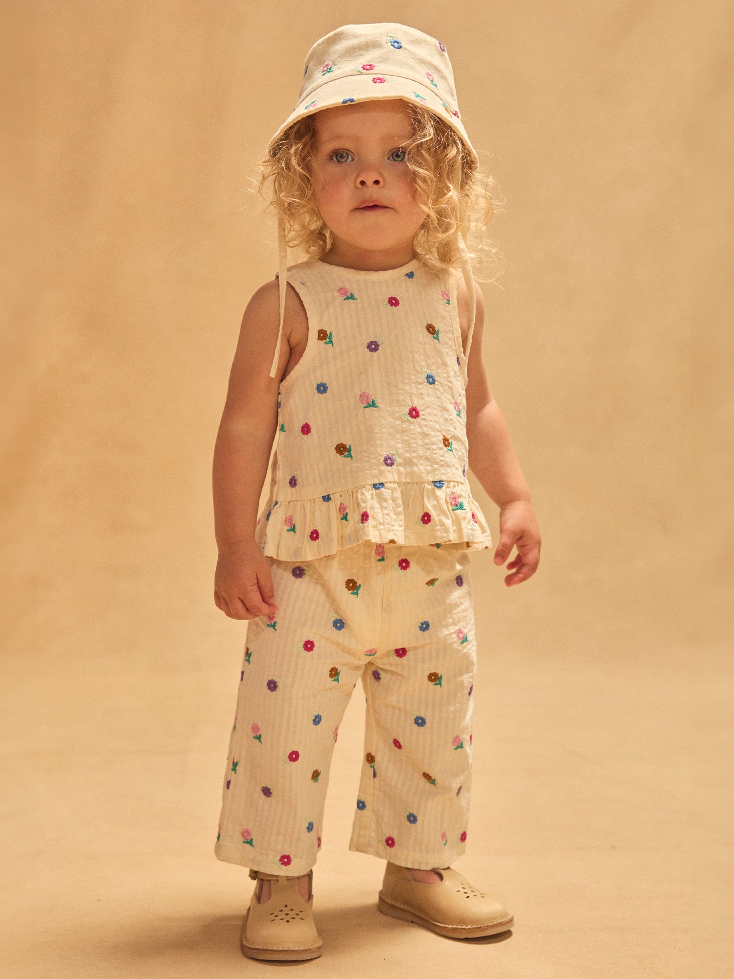 Pantalones crema con bordado floral para bebé niña